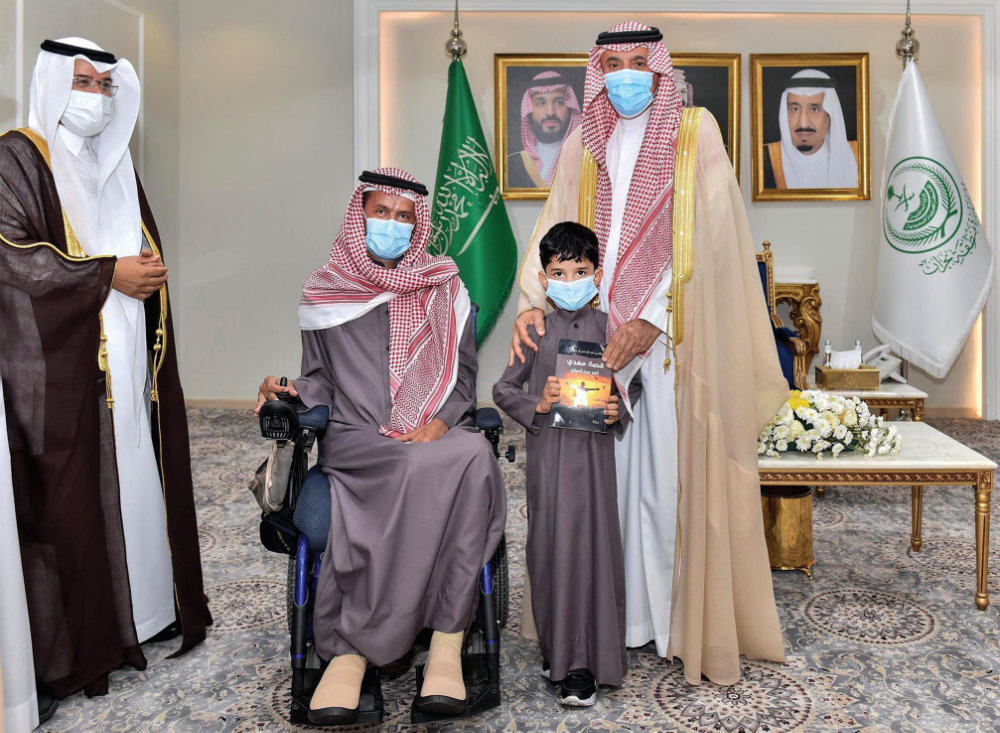 Najran Gov. Prince Jalawi bin Abdul Aziz is seen with author Mahdi Al-Mutlaq, Najran Literary Club Saeed Al-Mardamah and a child on Thursday. (SPA)