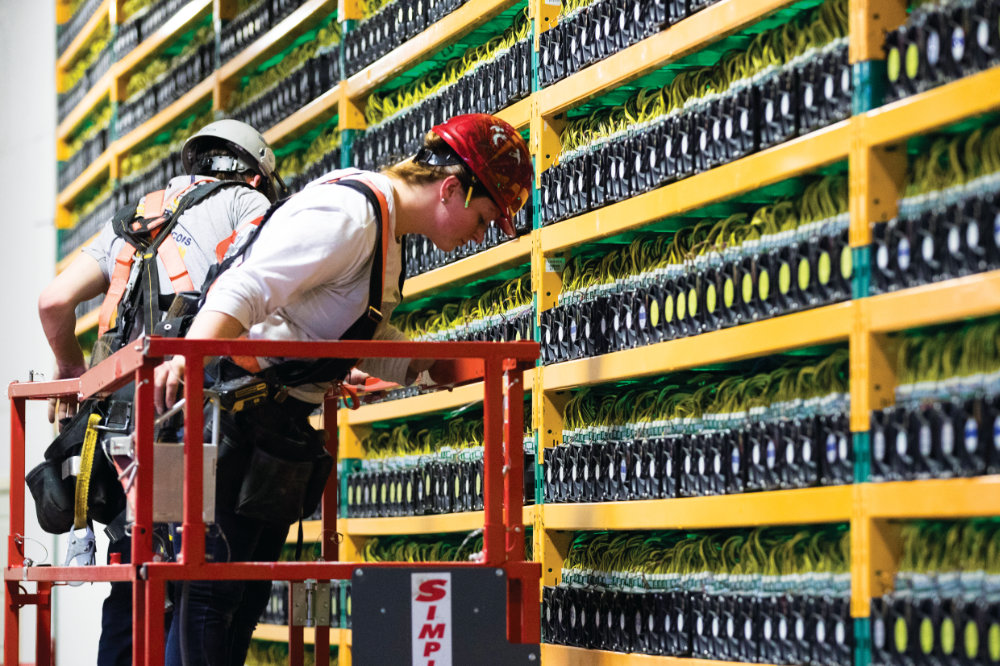 Workers at the bitcoin mining company Bifarms in Saint Hyacinthe, Quebec. Bitcoin volumes have doubled at four major North American platforms this year. (AFP)