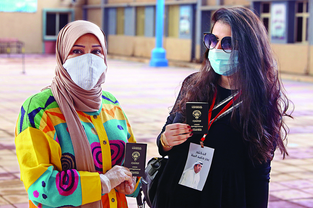 Women wait to cast their votes at a polling station in Kuwait City on Saturday. More than 300 candidates contested the National Assembly elections. AFP