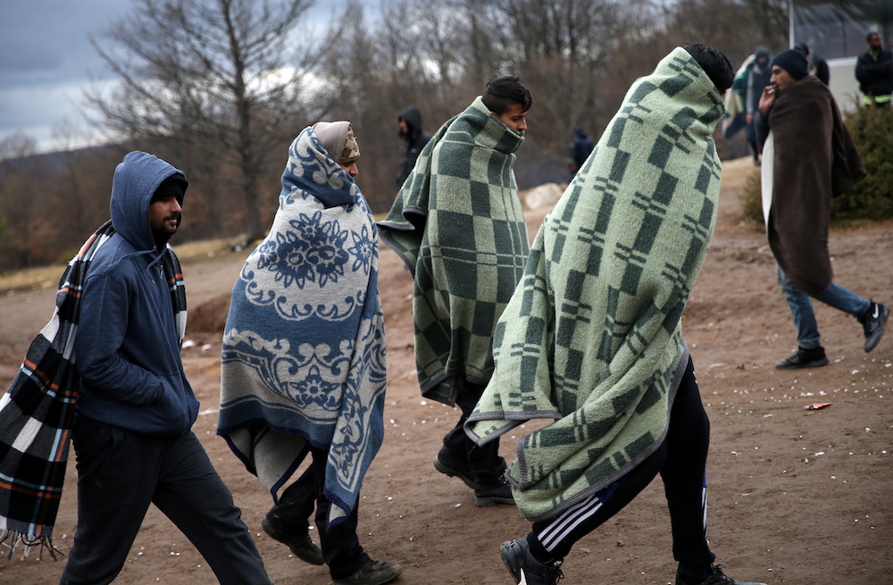 Migrants leave the burned migrant center “Lipa” in Bihac, Bosnia and Herzegovina Dec. 24, 2020. (Reuters)