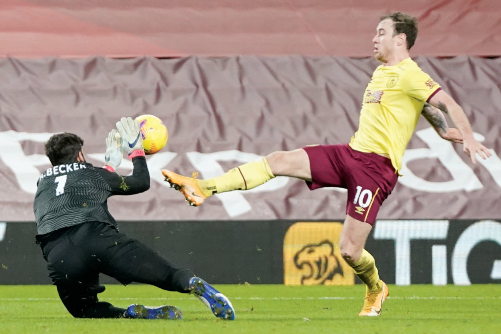 Liverpool’s Brazilian goalkeeper Alisson Becker, left,  fouls Burnley’s English striker Ashley Barnes during match in Liverpool, on Thursday. (AFP)