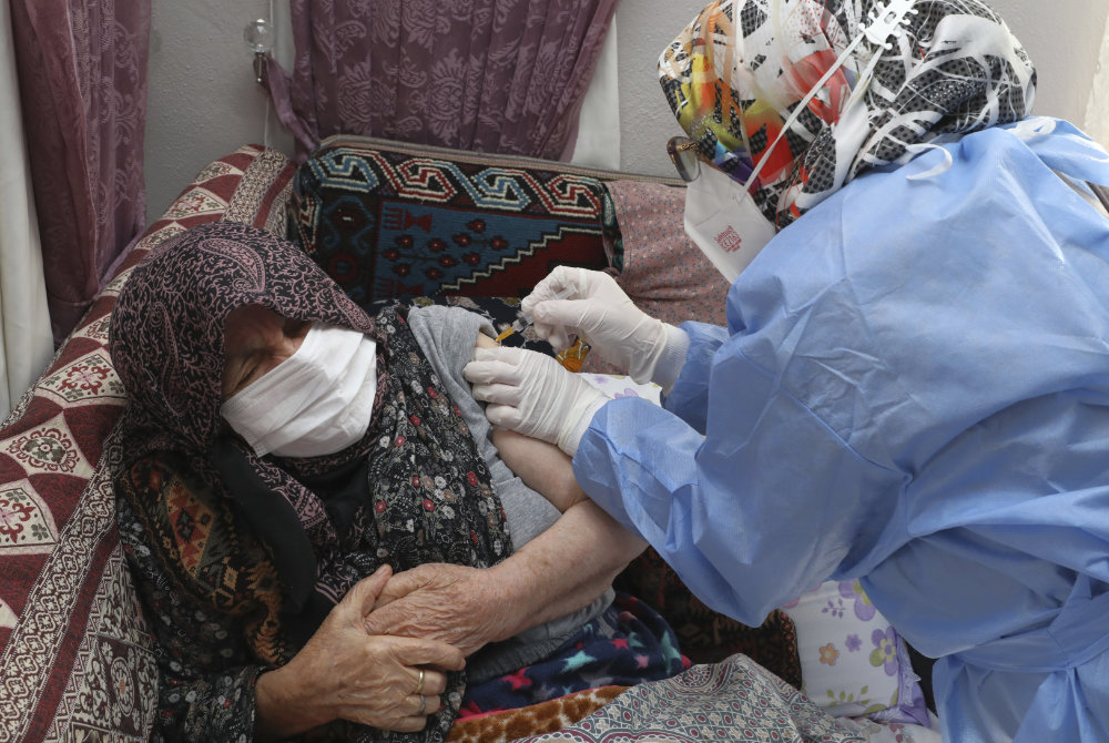 A Turkish Health Ministry health worker administers a dose of anti-COVID-19 vaccine on an 89-year-old woman in Ayas, in Ankara province, Turkey, on Jan. 21, 2021. (Turkish Health Ministry via AP) 