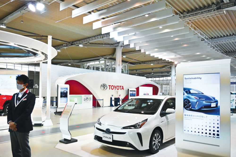 In this file photo taken on November 6, 2020, a staff member stands in a Toyota showroom in Tokyo. Japan’s Toyota reclaimed the title of world’s top-selling automaker in 2020, according to data released by the firm on January 28, 2021, pushing Volkswagen into second place for the first time in five years. (AFP file photo)