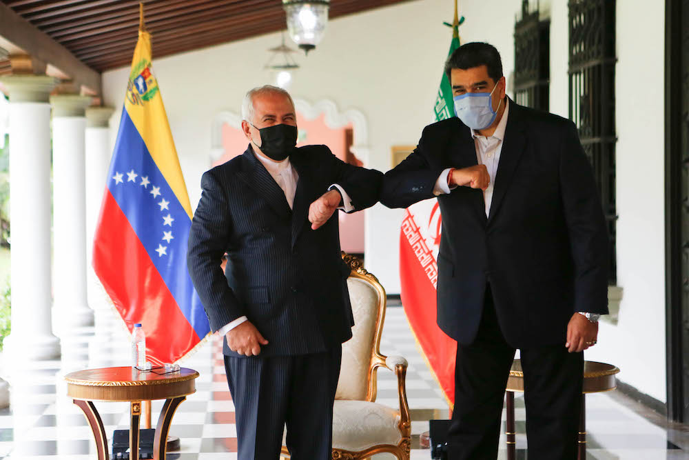 Handout picture released by Venezuelan Presidency showing Venezuela's President Nicolas Maduro (R) bumping elbows with the Foreign Minister of the Islamic Republic of Iran, Javad Zarif (L) at Miraflores Palace in Caracas, on November 5, 2020. (AFP/File Photo)