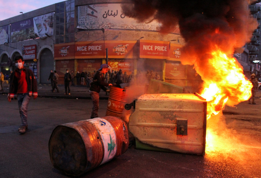 Garbage bins, set on fire by demonstrators, block a road during a protest in Tripoli, Lebanon on January 26, 2021 against the lockdown and worsening economic conditions amid the spread of the COVID-19. (REUTERS/Omar Ibrahim )