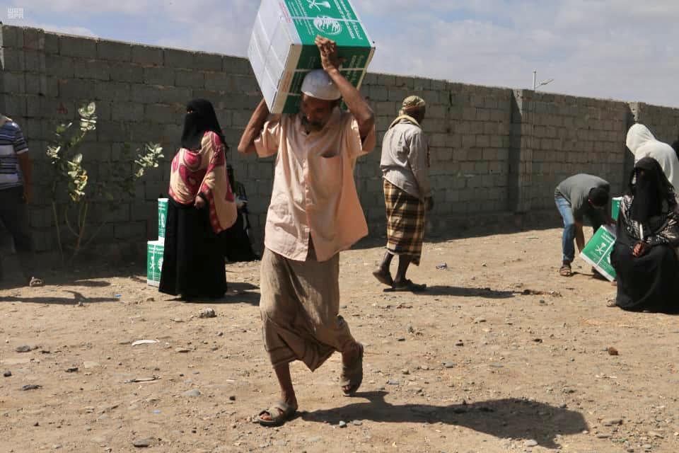 Sudanese bring home aid packages from KDrelief at a distribution center. (SPA)