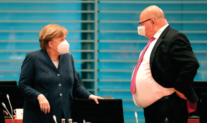 German Chancellor Angela Merkel and Economy Minister Peter Altmaier talk as they arrive for the weekly Cabinet meeting on Wednesday at the Chancellery in Berlin. (AFP file photo)