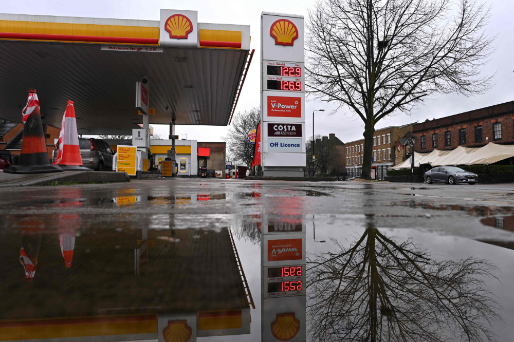 A Shell service station is reflected in a puddle in London on February 4, 2021. Royal Dutch Shell dived into a net loss of $21.7 billion in 2020 as the coronavirus pandemic slashed global energy demand. (AFP / JUSTIN TALLIS)