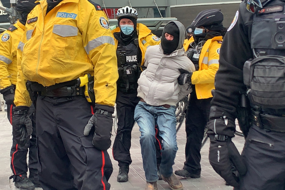 Toronto police officers, enforcing provincial emergency COVID measures, detain a pro-life demonstrator who was marching with a group protesting against COVID-19 restrictions in Toronto, Ontario, Canada, on February 6, 2021. (REUTERS/Kyaw Soe Oo)