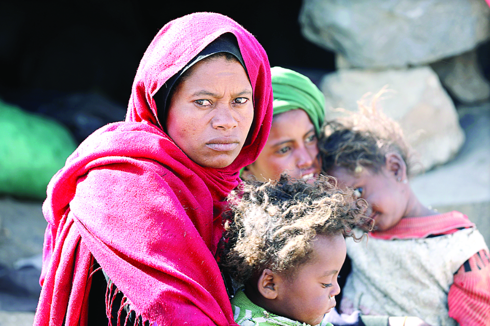 A woman sits with her children at a camp for internally displaced people on the outskirts of Houthi-occupied Sanaa as Iran-backed militias continue their attacks. (Reuters)