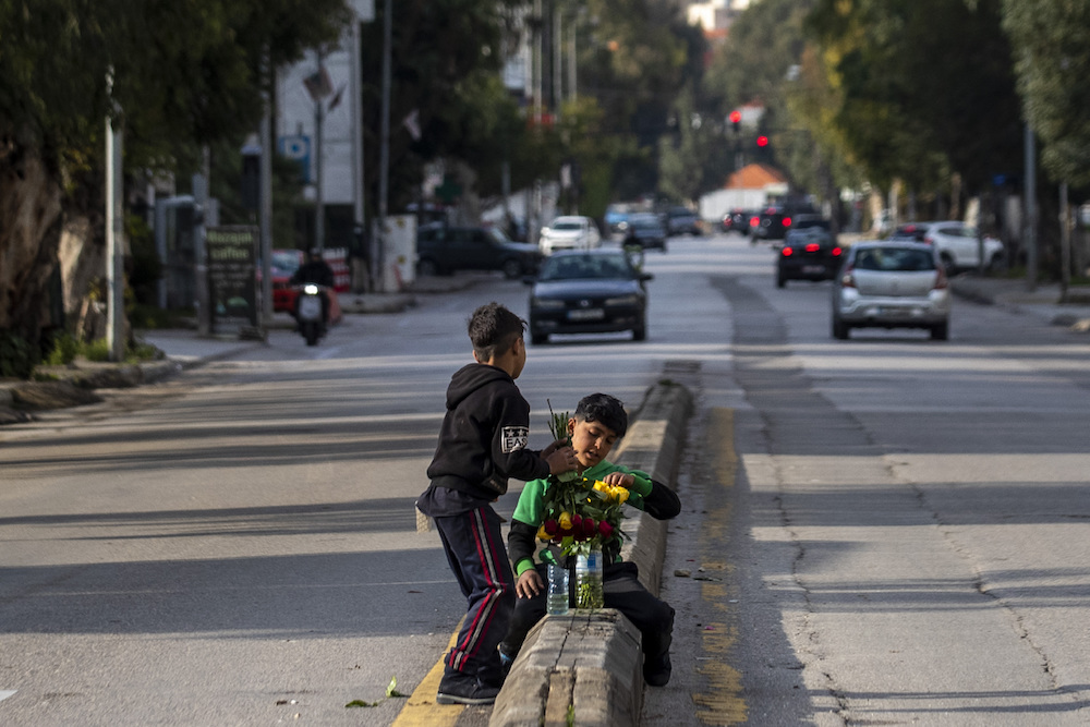 Syrian refugee children sell flowers at a traffic light in Beirut, Lebanon, Saturday, April 3, 2021. (AP)