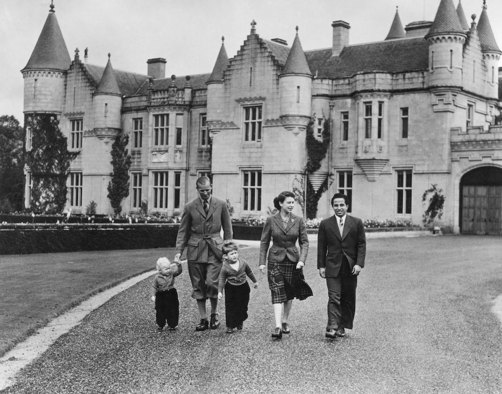 The British Royal Family walk in the park of Balmoral castle along with King Faisal II of Iraq, on September 26, 1952. (AFP/File Photo)