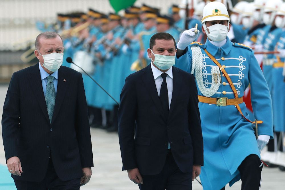 Turkish President Recep Tayyip Erdogan (L) and Libyan government of national unity prime minister Abdul Hamid Dbeibah (R) walk past honour guards during the official ceremony prior to their meeting in Ankara on April 12, 2021. (AFP/File Photo)