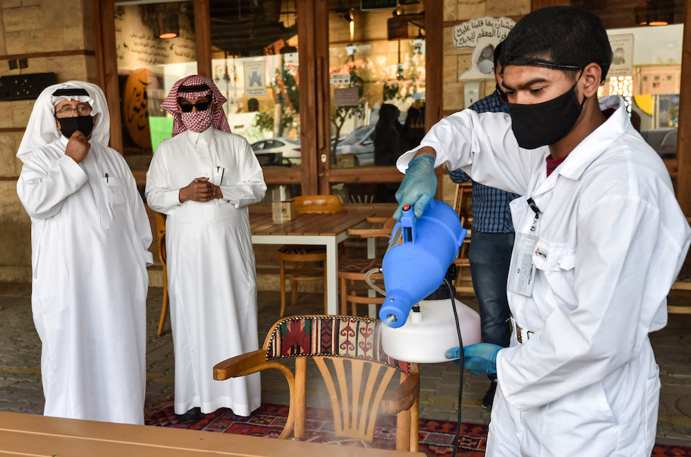 A worker sanitises a table for clients at a cafe in Saudi Arabia's capital Riyadh on June 21, 2020, as the country begins to re-open following the lifting of a COVID-19 lockdown. (AFP/File Photo)