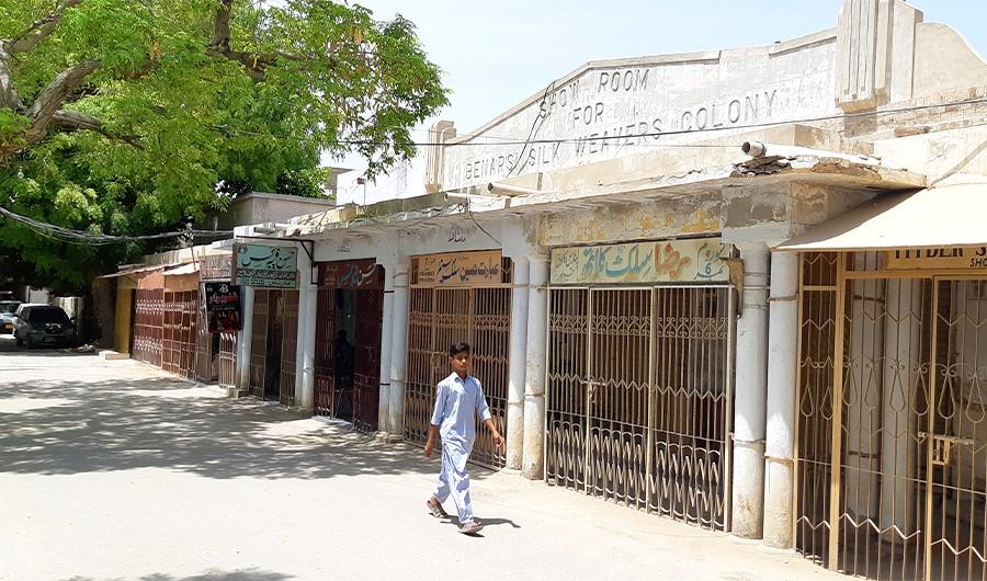 A boy walks past Banarsi Sari Market in Banarsi Silk Weavers Colony in Khairpur, Sindh. (AN photo by Zulfiqar Kunbhar)