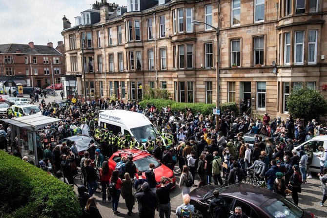 Protestors surround an Immigration Enforcement van to stop it from departing after individuals were detained in Glasgow in May. (AFP/File Photo)