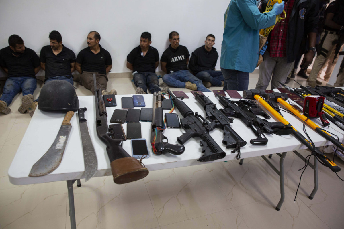 Suspects in the assassination of Haiti's President Jovenel Moise, along with the weapons and equipment they allegedly used, are shown to the media at Port-au-Prince on July 8, 2021. (AP Photo / Joseph Odelyn)