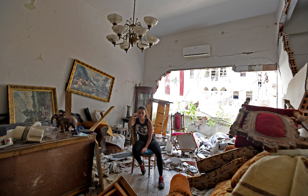 a woman sits amidst the rubble in her damaged house in the Lebanese capital Beirut on August 6, 2020, two days after a massive chemical explosion at the port in Beirut. (AFP/File Photo)