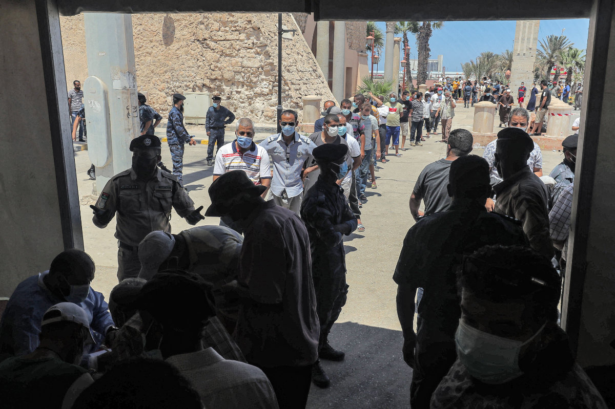 People queue outside a make-shift COVID-19 vaccination and testing center erected at the Martyrs' Square in Tripoli,  Libya, on on July 24, 2021. (AFP)