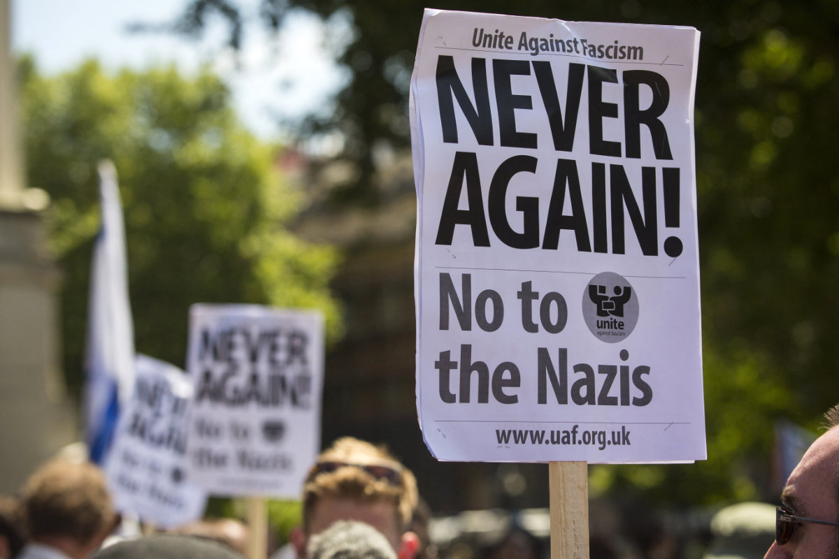 Placards are held up at a counter-demonstration to an anti-Jewish rally, held by a group of far-right protesters on Whitehall in central London on July 4, 2015. (AFP)