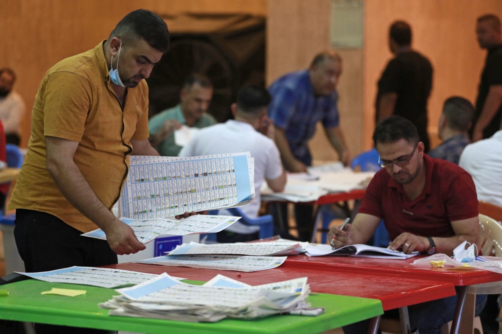 Employees of Iraq’s Independent High Electoral Commission conduct a manual count of votes following the parliamentary elections in Baghdad’s Green Zone area on Oct. 13, 2021. (AFP)