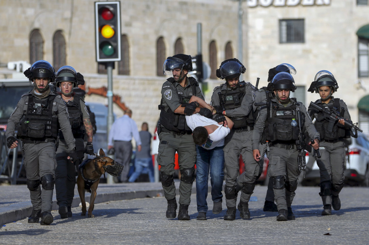 Israeli border police officers detain a Palestinian youth during clashes as thousands of Muslims flocked to Jerusalem's Old City on Oct. 19, 2021. (AP Photo)