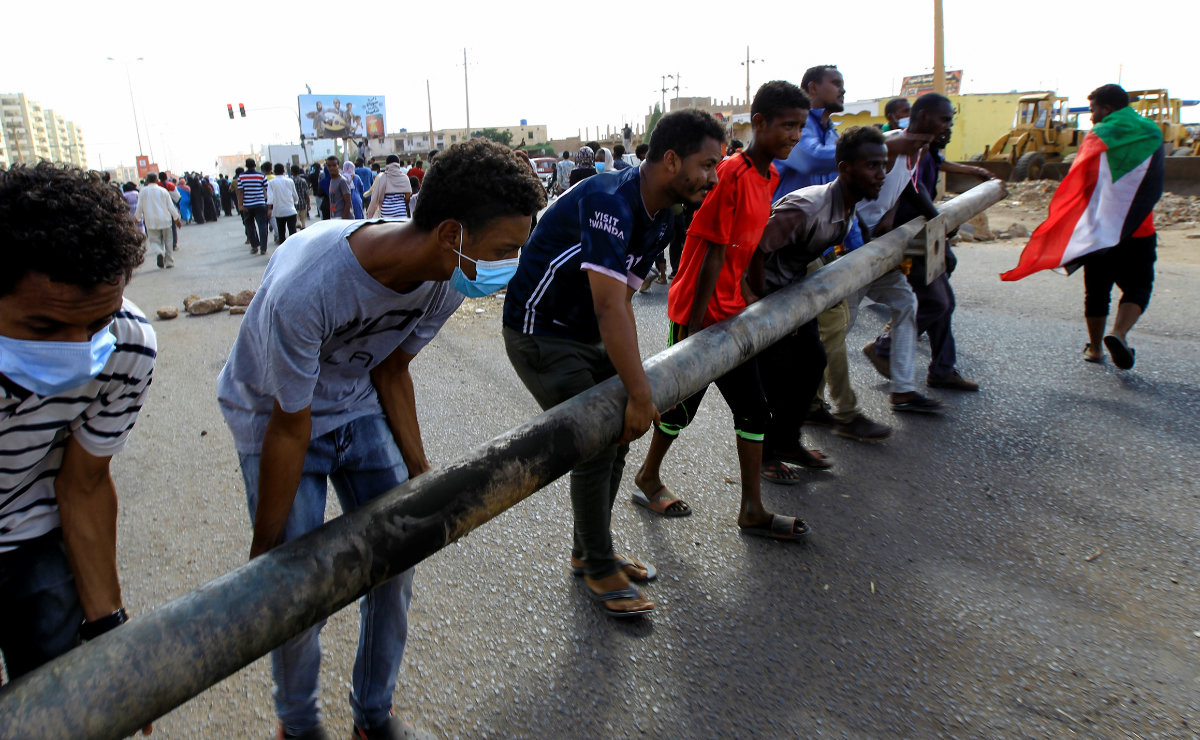 Protesters put up a barricade as they demonstrate along a street in Khartoum on Oct. 30, 2021, against the Sudanese military's recent seizure of power and ousting of the civilian government. (REUTERS/Mohamed Nureldin)