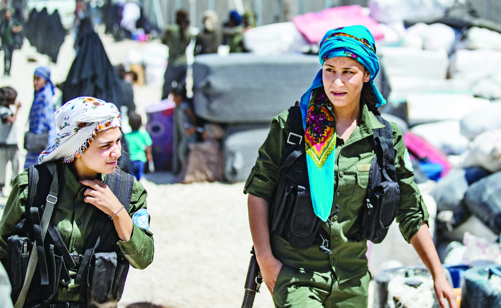 Fighters from the Syrian Democratic Forces patrol inside the Al-Hol camp. (AFP)