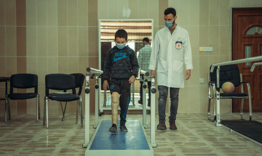 An Iraqi boy who lost a leg during a rocket attack in Mosul in 2017 gets prosthetics services from the Red Cross. (ICRC.org photo)