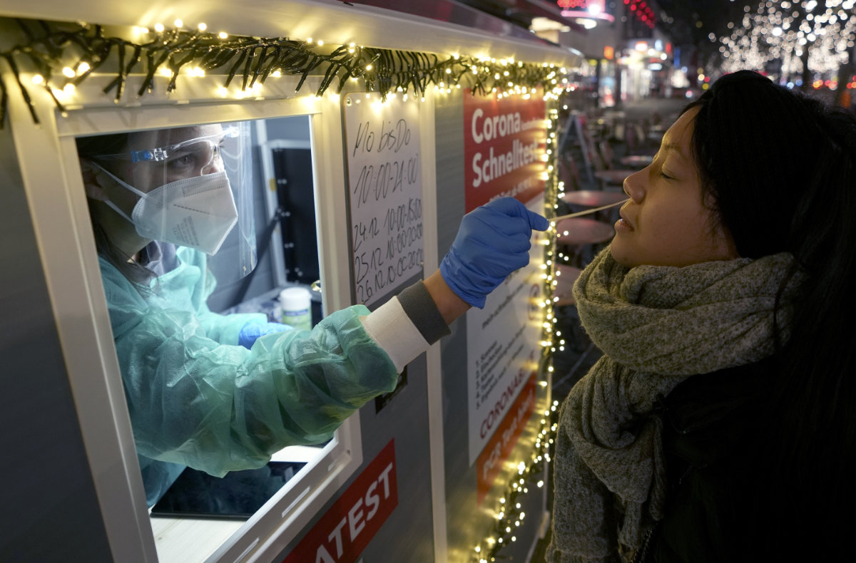 A health worker performs a coronavirus test at a shopping road in Berlin, Germany, on Dec. 21, 2021.(AP Photo/Michael Sohn) 