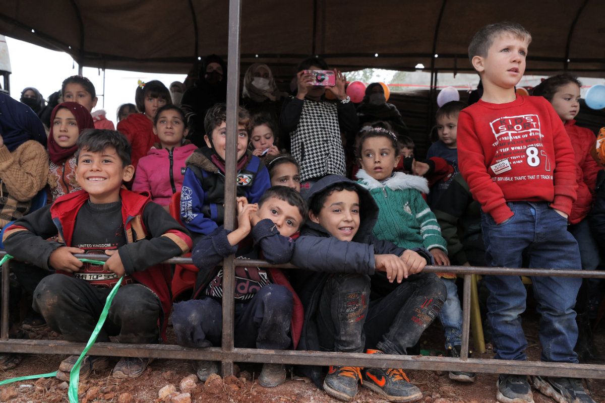 Children attend an outdoor event celebrating World Children's Day at the Haranbush camp for displaced Syrians in Syria's rebel-held Idlib province on Nov. 20, 2021. (OMAR HAJ KADOUR / AFP)