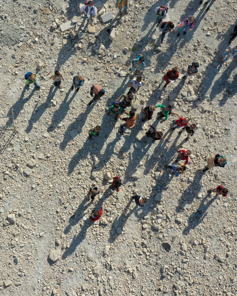 Children help put together tables and chairs to use in class as they attend the first day of school in a village in the countryside of Syria's Idlib province on Oct. 9, 2021. (Omar Haj Kadour / AFP)