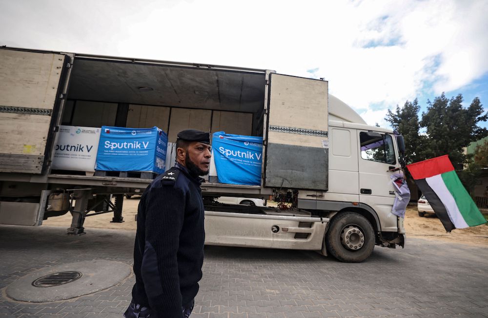 A Palestinian security officer stands at attention during the arrival of the Sputnik V vaccine, donated by the UAE, at a cold storage warehouse in Gaza City on Jan. 26, 2022. (AFP)