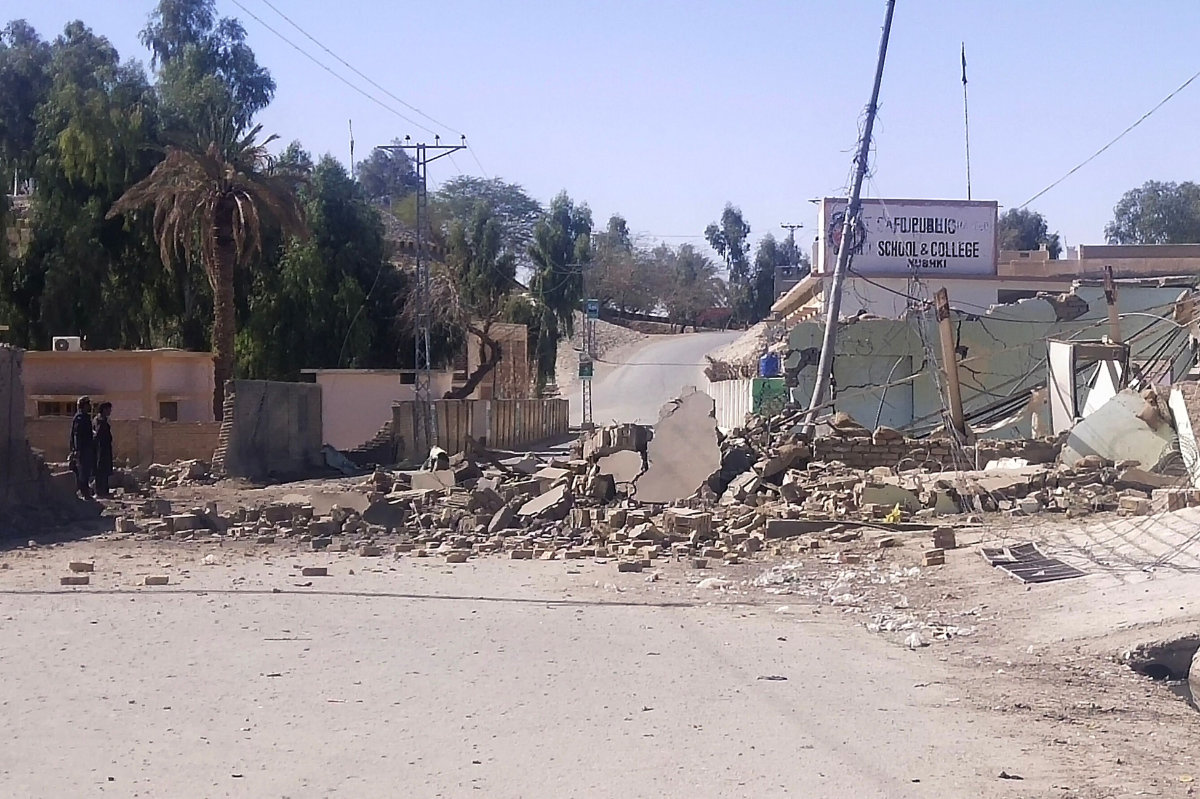 Security personnel stand beside a destroyed security post on Feb. 3, 2022 following overnight attacks by militants on security camps in Naushki district of Balochistan province. (AFP Photo)