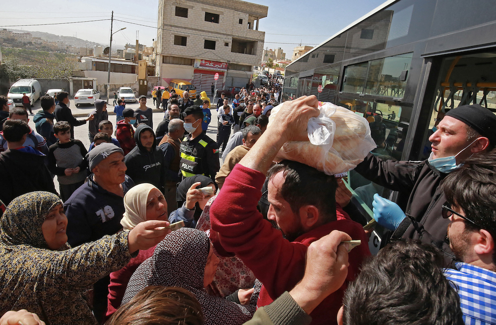 People queue to buy subsidised bread from a municipal bus in the Marka suburb in the east of Jordan's capital Amman. (AFP/File Photo)