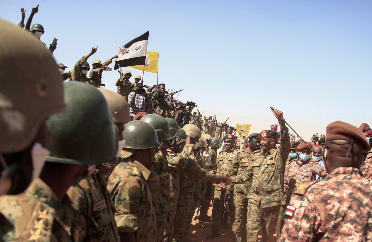 Sudan's top general Abdel Fattah al-Burhan greets soldiers during military exercise in the Maaqil area in the northern Nile River State on Dec. 8, 2021. (Photo by Ebrahim Hamid / AFP)