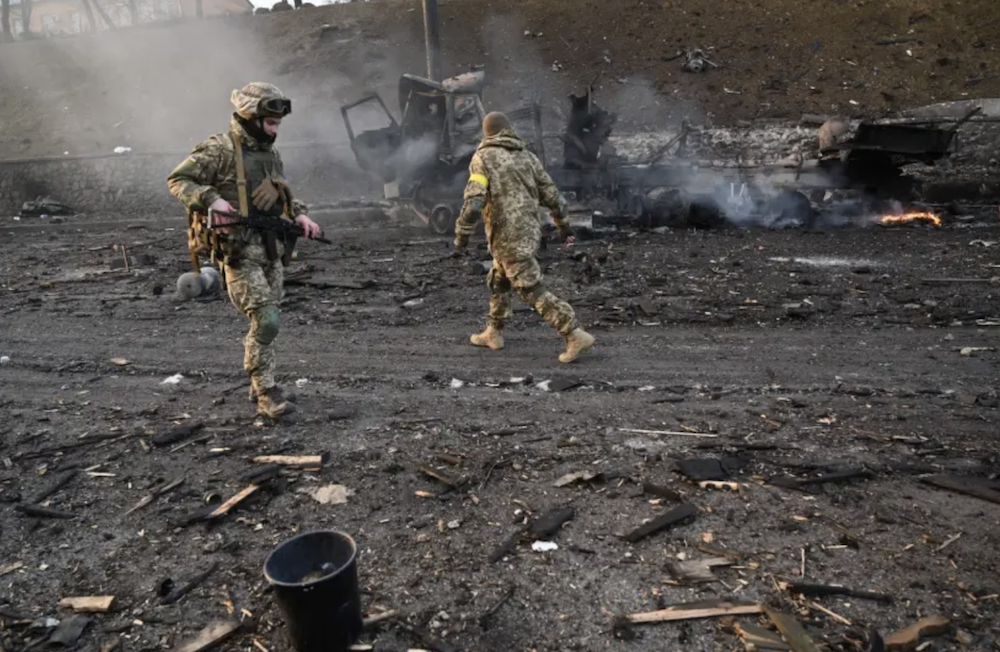 Ukrainian service members look for unexploded shells after a fighting with Russian raiding group in the Ukrainian capital of Kyiv in the morning of February 26, 2022. (AFP)