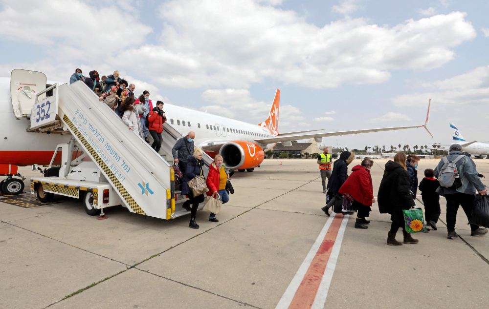 Ukrainian Jewish refugees, who fled the war in their country, disembark from a plane upon their arrival at Israel's Ben Gurion Airport in Lod, on March 17, 2022. (AFP)