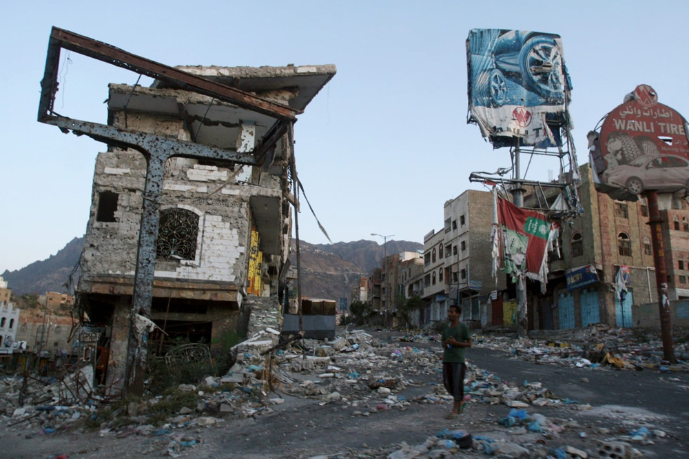 A man walks past a building destroyed during fighting in Yemen’s southwestern city of Taiz. (Reuters)