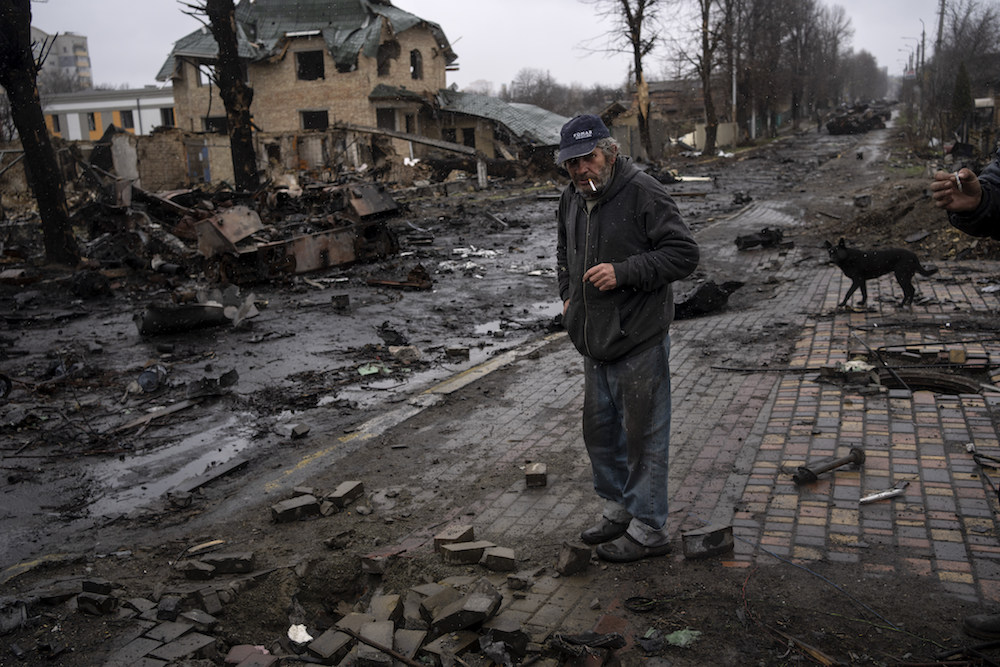 Konstyantyn, 70, smokes a cigarette amid destroyed Russian tanks in Bucha, in the outskirts of Kyiv, Ukraine. (AP)