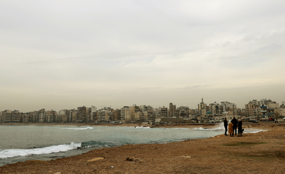 Lebanese people walk by the shores of Al-Mina in the Lebanese port city of Tripoli north of Beirut on Dec. 13, 2021. (AFP)