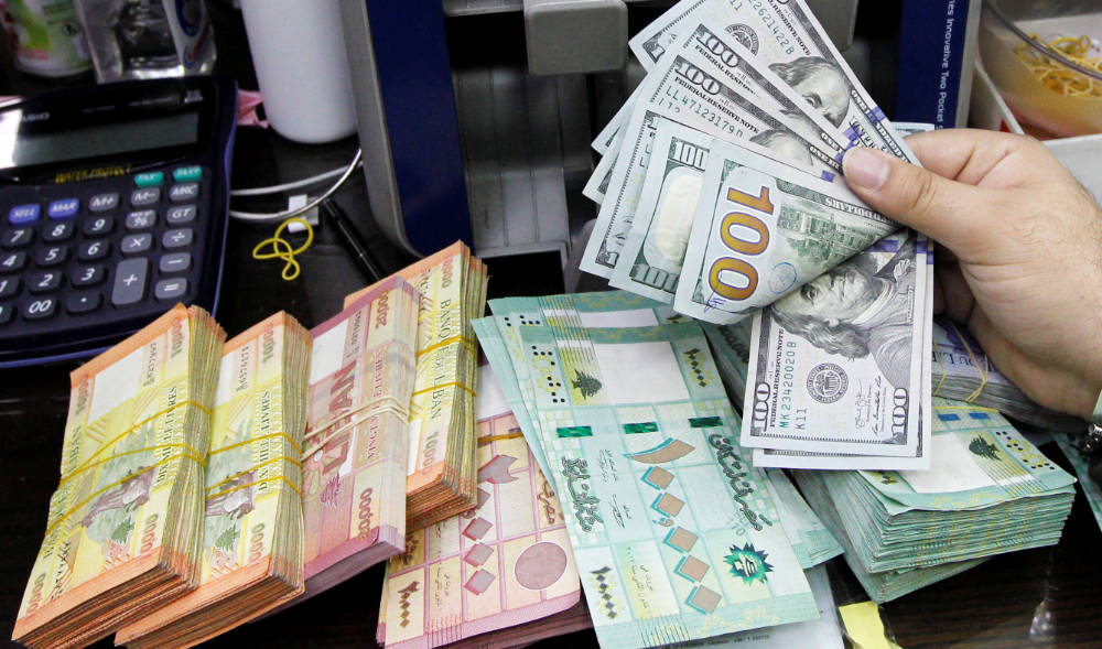  A man counts U.S. dollar banknotes next to Lebanese pounds at a currency exchange shop in Beirut, Lebanon. (REUTERS file photo)