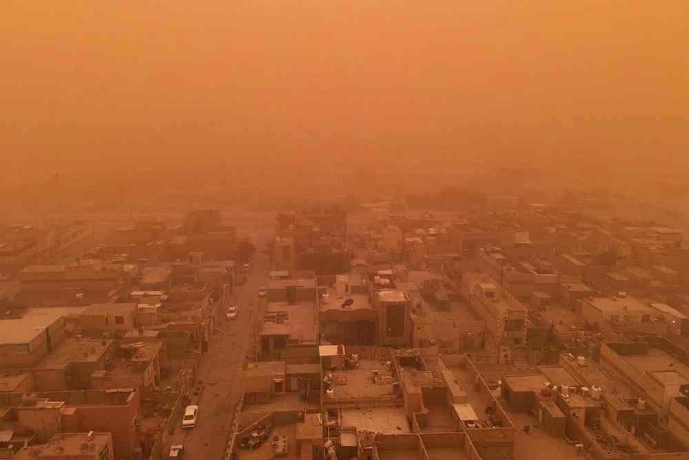 A aerial picture taken by drone shows the southern Iraqi city of Najaf during a dust storm on May 1, 2022. (AFP)