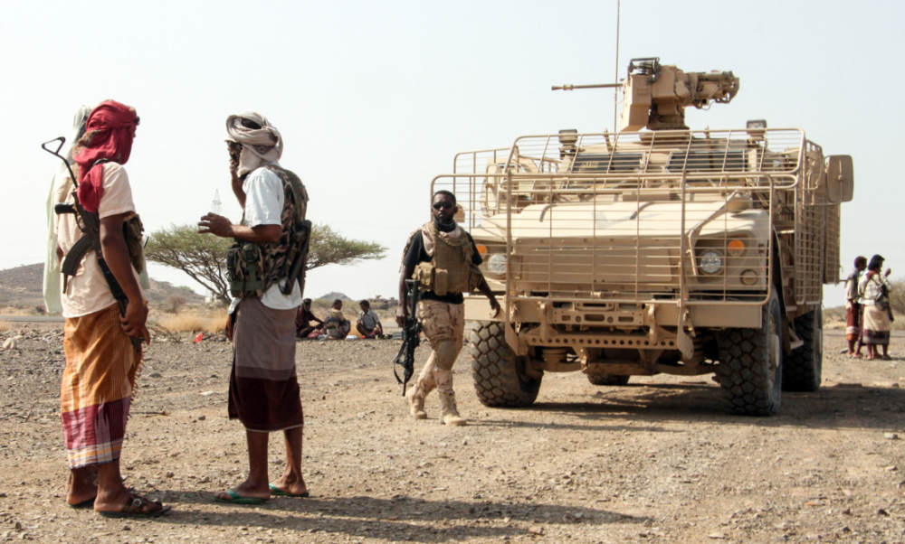 Yemeni government fighters stand by armoured vehicles at a position which was taken from Houthi rebels in a mountainous region northwest of the central city of Taiz. (AFP)