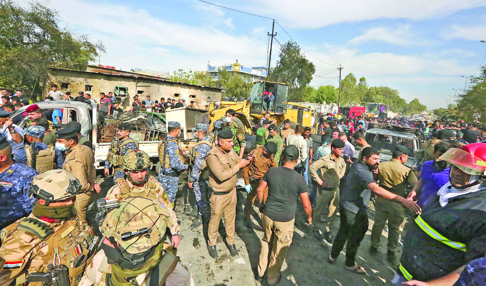 Members of the Iraqi army and security forces gather at the scene of a deadly explosion carried out by Daesh terrorists in Baghdad last year. (AFP)