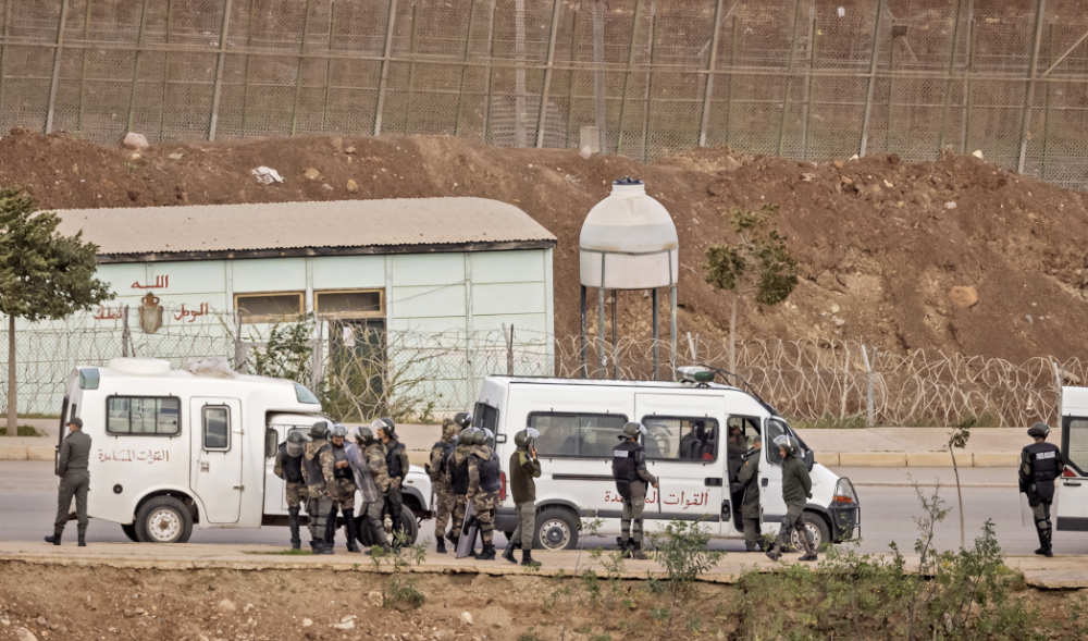 Paramilitaries of the Moroccan Auxiliary Forces stand guard by the border fence separating Morocco from Spain's North African Melilla enclave on March 4, 2022. (AFP)