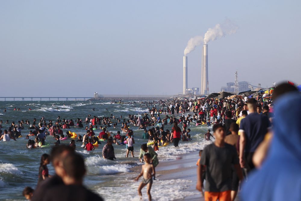 Palestinians swim in the Mediterranean sea off a beach in Beit Lahia in the northern Gaza Strip on June 10, 2022. (AFP)