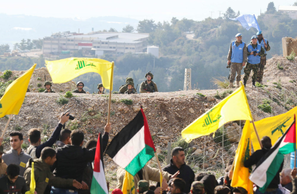 Israeli soldiers (top L) and UN peacekeepers (top R) look at Lebanese supporters of the Shiite Hezbollah movement attending a rally on January 28, 2018, in Alma al-Shaab, on the border with Israel. (AFP)