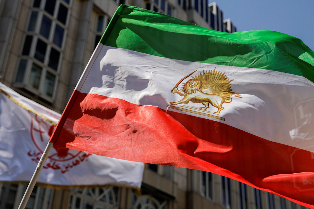 A flag is waved in front of Palais Coburg where closed-door nuclear talks with Iran take place in Vienna, Austria, Aug. 4,2022. (Reuters)