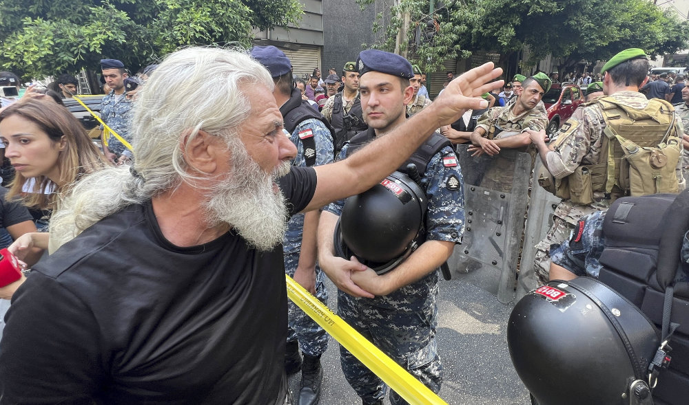 A man shouts as he protests against banks outside a bank where another armed man holds hostages in Beirut, Lebanon, Thursday, Aug. 11, 2022. (AP)